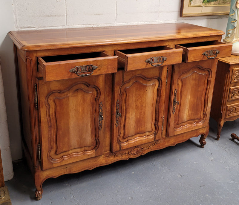 Beautiful French three door three drawer Louis XV style Cherrywood sideboard. It has a total of four adjustable shelves and comes with three keys. It has been sourced from France and is in good original detailed condition.