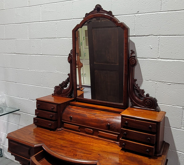 Beautiful Flame Mahogany Victorian duchess dressing table. Circa 1880 in date. It has a serpentine front outline and has an adjustable swing frame mirror. It is fitted with a central roll up storage section and then has three small drawers to either side, aswell as a central drawer in the middle of the serpentine front. It is in good original condition.