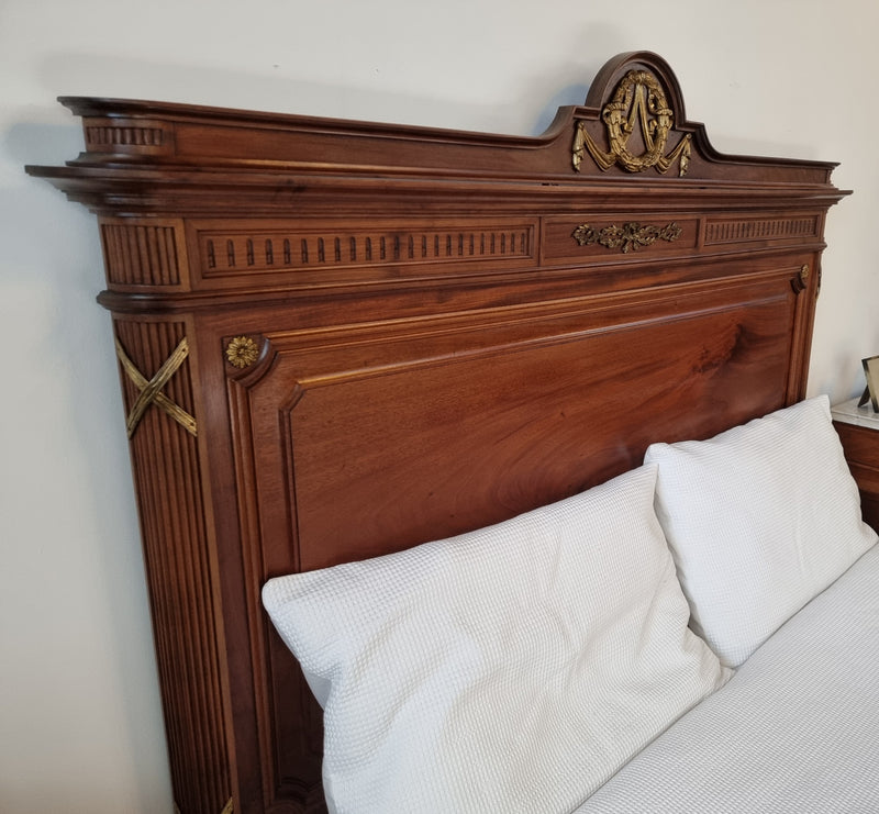 Louis XVI style Mahogany Queen size bed on original castors. This bed has beautiful carved details and and Ormolu mounts in good original detailed condition