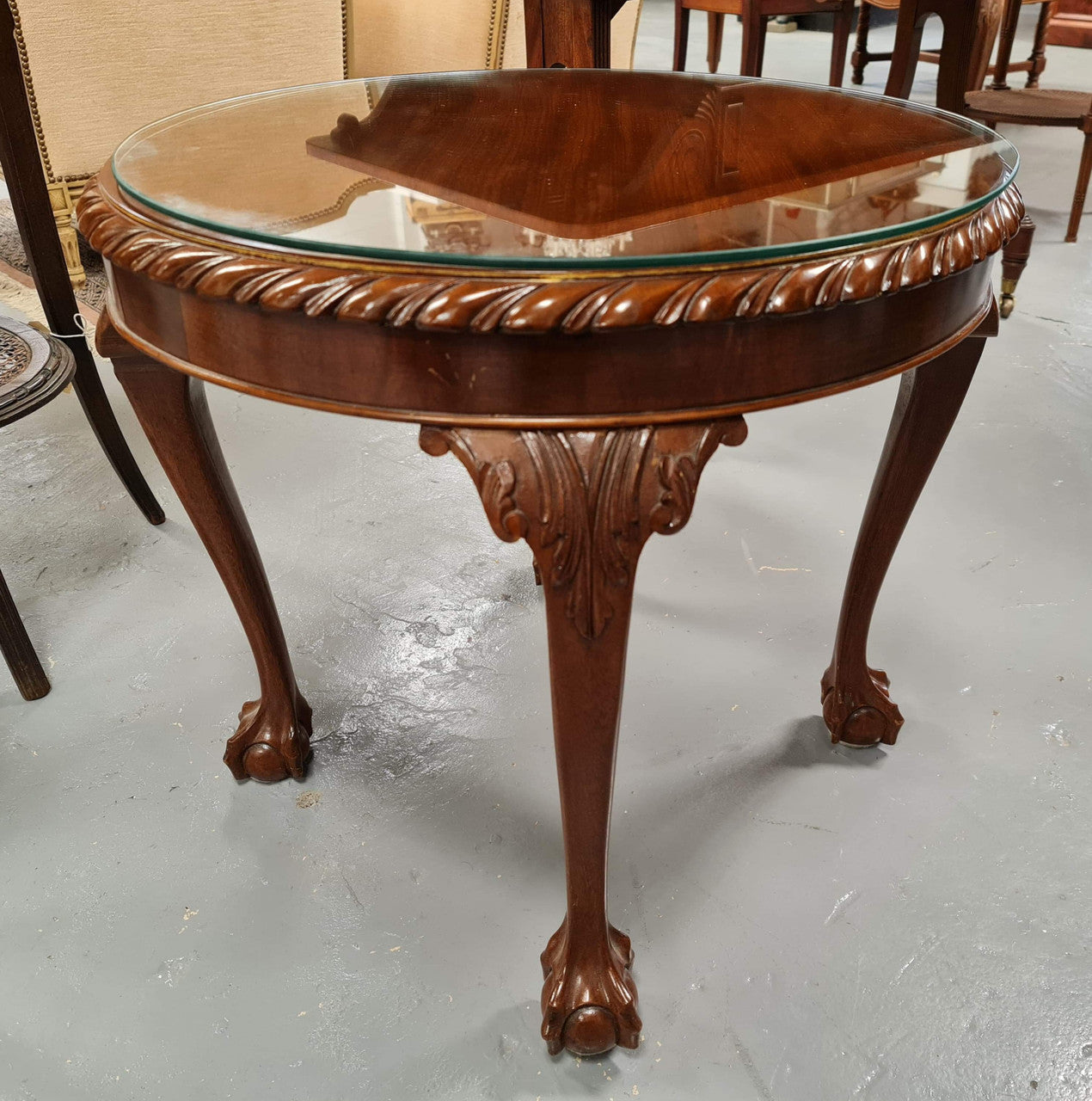 A beautiful round Mahogany Chippendale style coffee table with a glass top. In good original detailed condition.