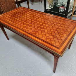 Beautiful French Louis XVI style inlaid coffee table with a brass band and glass top. In good original detailed condition.