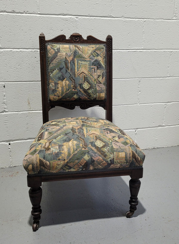 Single upholstered Edwardian nursing chair. Fabric is in good original used condition and chair has four caster wheels and is in good original condition.