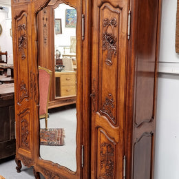 French Walnut Louis XV style three door armoire with 10 fully adjustable shelves in total spread over three sections, two drawers and a mirrored middle door. It has been sourced from France and in good original detailed condition.