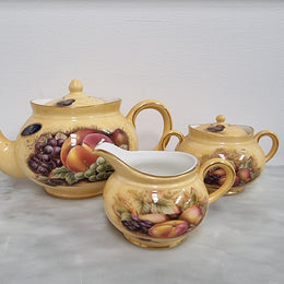“Aynsley Orchard Gold” tea set on tray. Consisting of small teapot, lidded sugar and creamer. Please view photos as they help form part of the description.