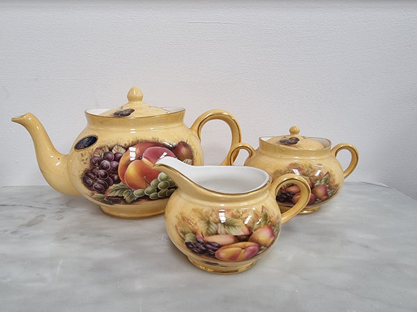 “Aynsley Orchard Gold” tea set on tray. Consisting of small teapot, lidded sugar and creamer. Please view photos as they help form part of the description.