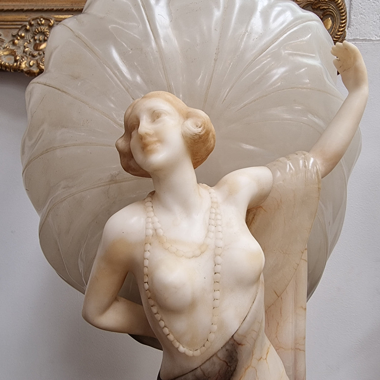 Monumental Art Deco alabaster and marble figural lamp modelled as a seductively dressed semi naked woman. In subtlety coloured diaphanous robes with a large clam shell light backdrop. Italian circa 1920's signed to base. This is a world class example of a true Art Deco sculpture lamp. It is in good original detailed condition, please view photos as they help form part of the description.