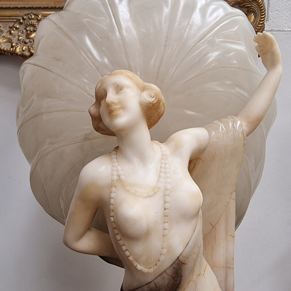 Monumental Art Deco alabaster and marble figural lamp modelled as a seductively dressed semi naked woman. In subtlety coloured diaphanous robes with a large clam shell light backdrop. Italian circa 1920's signed to base. This is a world class example of a true Art Deco sculpture lamp. It is in good original detailed condition, please view photos as they help form part of the description.