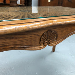 Lovely French Oak Louis XV style cane top coffee table with a glass top. In good original detailed condition.