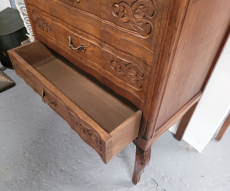 French Oak Louis XV style three drawer commode. It has been sourced from France and has decorative handles and carvings. It is in good original detailed condition.