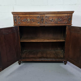 18th century French Oak Tall sideboard with beautiful carvings. It has plenty of storage with two drawers at the top and two doors at the bottom with a fixed shelf inside. It is in good restored condition.