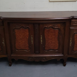 Fabulous Louis XV style French Walnut and Burr Walnut four door sideboard. Each door panel has beautiful Burr Walnut panels and open up to an adjustable shelf. Beautiful handles and two drawers for added storage. In good original detailed condition.