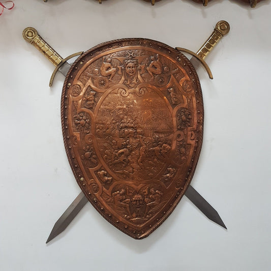 A beautiful European Antique highly detailed embossed copper shield with swords. Look closely to see the amazing detail in the shield of a fighting scene. It has brass handles on the steel swords. Is in good original condition with a slight crack (see photo).