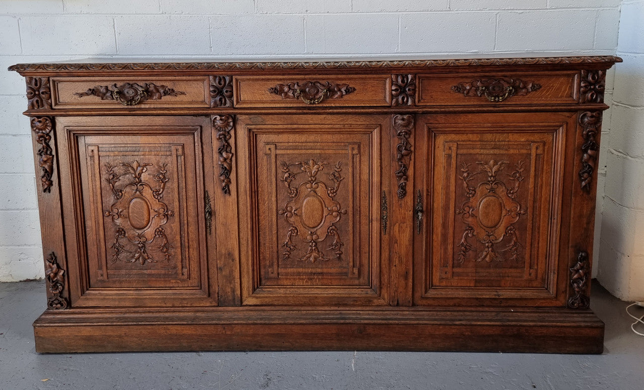 Stunning 19th Century French Oak Renaissance style sideboard base of hard to find dimensions. Amazing detailed carving with three cupboards and three drawers. It is in good original detailed condition.