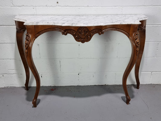 An elegant walnut French Louis XV style white marble top console table. It is in good original detailed condition.