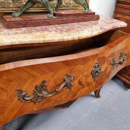 Attractive French Louis XV style walnut two drawer marquetry inlaid commode. With impressive ormolu handles and trims and shaped marble top. It has been sourced from France and is in good original detailed condition.