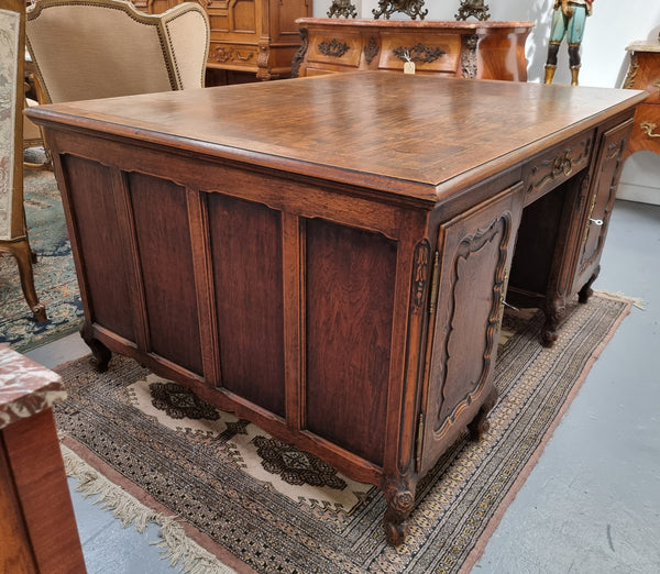 Fabulous Louis XV style French Oak beautifully carved full partners desk. Both sides have a functioning drawer in the middle and two cupboards either side. On both sides one cupboard door opens up to four smaller internal drawers. Plenty of storage space and a large top surface to work on. It is in good original detailed condition.