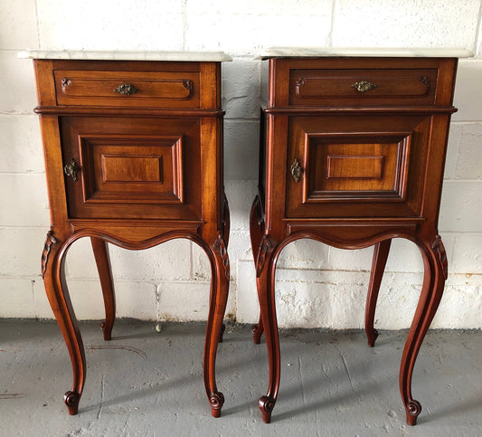 Matched pair of French mahogany Louis XV style bedside cabinets. They have white marble tops and have been directly sourced from France. They are in good original detailed condition, circa 1900's.