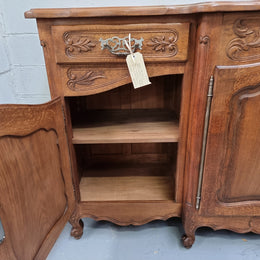 Parquetry top French oak Louis XV style sideboard with two draws and four cupboards. In good original detailed condition.