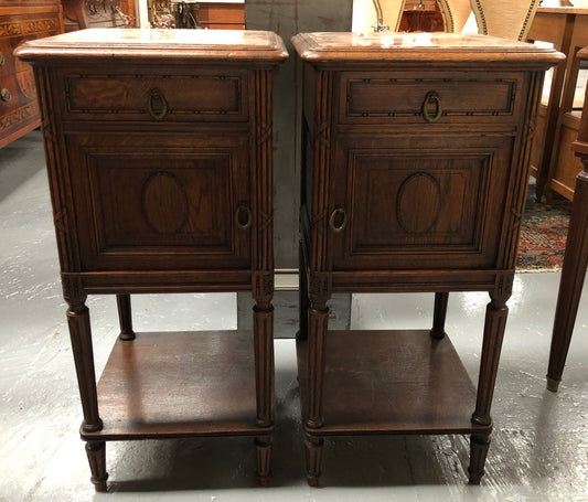 Lovely pair of French Oak Louis XVI style bedside cabinets with inset marble tops a drawer and a cupboard for storage. In good original detailed condition.