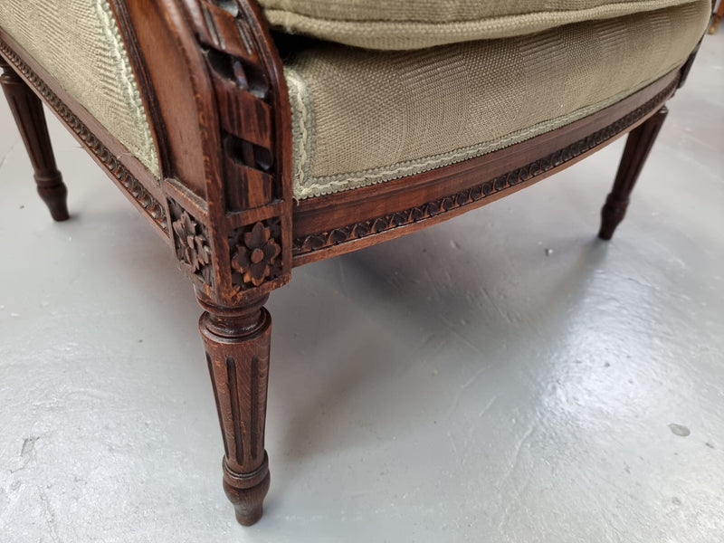 Beautifully carved Louis XVI Walnut upholstered wingback chair. The upholstery is in good original condition with no tears. The chair is also in very good original condition.