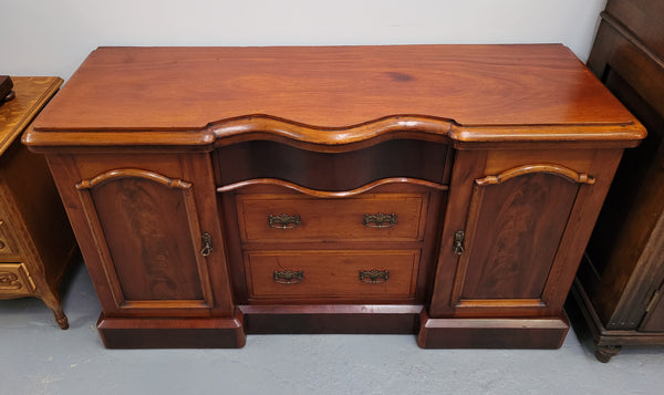 An English Victorian Mahogany sideboard with nine drawers. This amazing piece has loads of storage with three central drawers in the middle and a further six drawers. It has three each side located behind two doors. It has been sourced from locally and in original detailed condition.