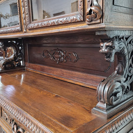 Grand French Oak Gothic style buffet with amazing detailed carvings. This stunning buffet has a display section at the top with two adjustable shelves, two drawers in the middle with elegantly carved handles and storage below with one fixed shelf. It is in good original detailed condition.