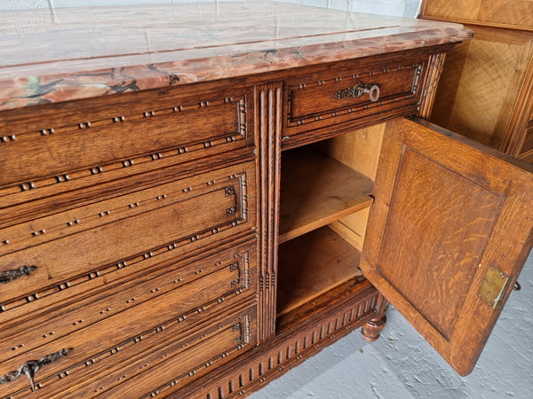 Absolutely beautiful French oak sideboard. It has 6 drawers and 2 cupboards for all your storage needs. There is a lovely coloured marble top and beautiful carving on the doors in good original detailed condition.