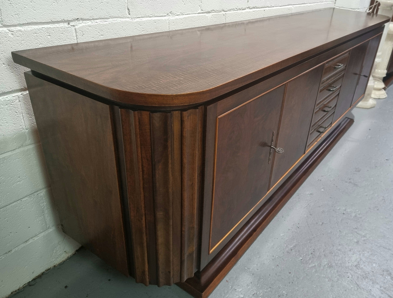 Amazing French Walnut Art deco four door buffet. The doors either side open to a fixed shelf and plenty of added storage with four drawers. In good original detailed condition.