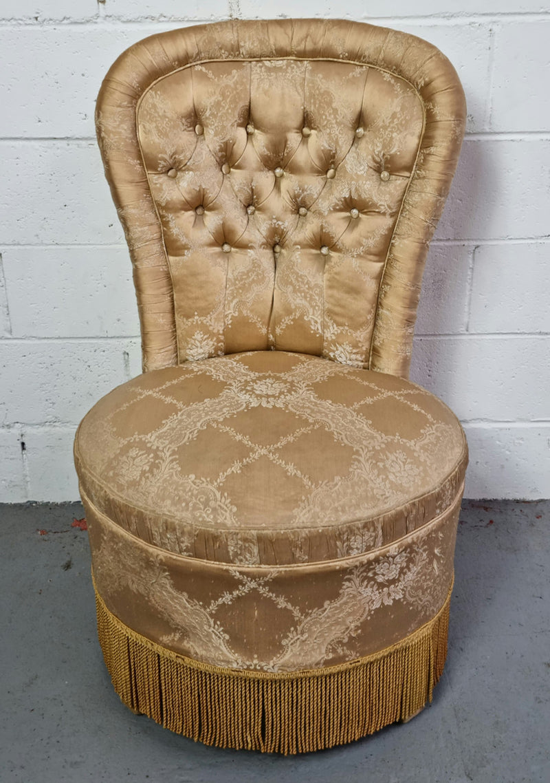 Vintage round upholstered button back bedroom chair. Beautiful gold upholstery in original condition with a gold fringe.