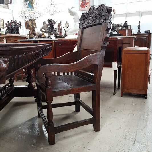 An impressive late 17th century oak, Charles II Wainscot chair, with all original panel timber, solid seat, turned arm supports and original top carved panel. This chair retains it's beautiful patina and comes with upholstered cushion seat.