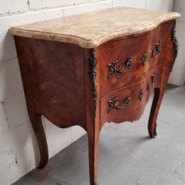 A timeless and compact French Louis XV style two drawer Kingwood marquetry inlaid commode. It features a stunning marble marble top and decorative mounts. The compact design of this commode ensures versatility, making it a perfect addition to any living space, bedroom or hallway. It has been sourced directly from France and is in good original detailed condition.