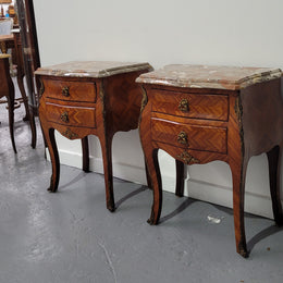 Pair of Louis XV commode style two drawer bedsides with beautiful marble tops and decorative mounts. They are a rare size and are in good, detailed condition.