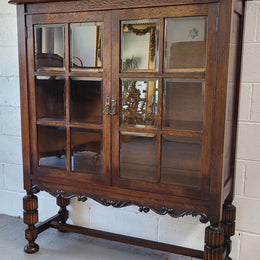 Tudor oak 2 door astral glaze and beveled glass bookcase.  Good original condition. Circa 1930s.