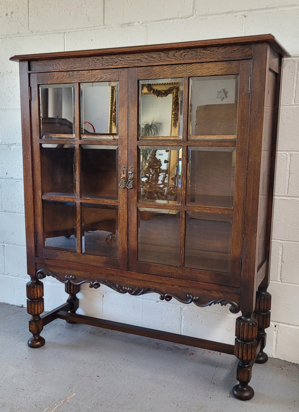 Tudor oak 2 door astral glaze and beveled glass bookcase.  Good original condition. Circa 1930s.