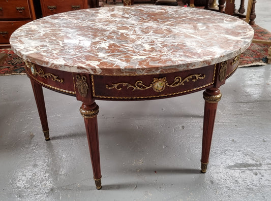 Stunning Antique French style Burr Walnut marble top coffee table. It has gilt metal mounts all around the top edge, with more down the fluted legs & feet. It also has exquisite painted porcelain plaques encased in gilt metal laurel wreaths all around the top edge. It is also stamped underneath "Muarva S.L. Made In Spain". It is in good original detailed condition.