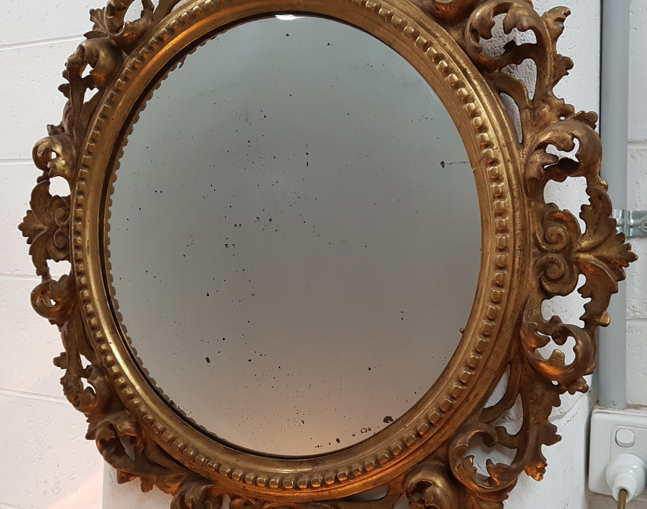 Large round carved wooden convex mirror. Still contains its original mirror which shows signs of aging.