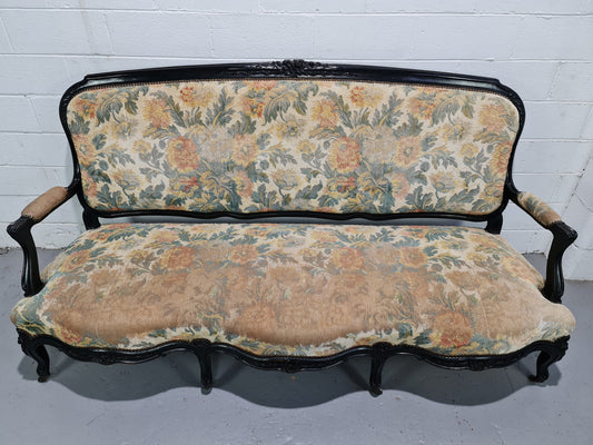 A Substantial Antique 19th Century Louis XV style ebonized serpentine front settee. The fabric is in used condition showing use and could be used as is or reupholster.