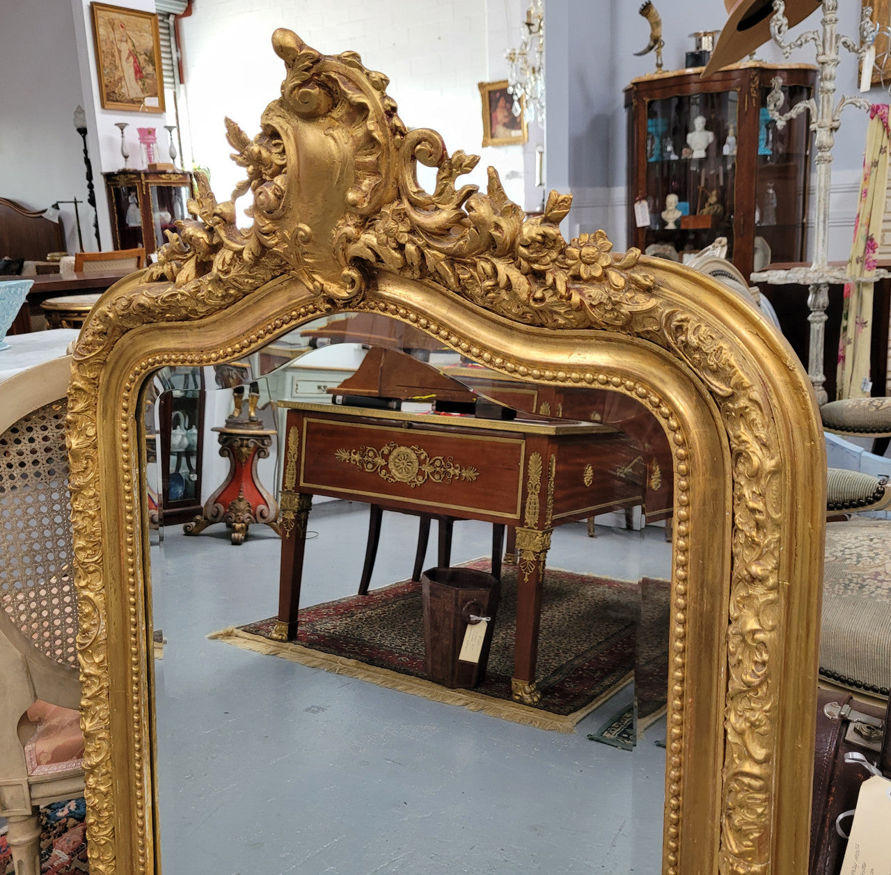 Beautiful French Napoleon III Louis XV style gilt framed bevelled mirror with an ornate crest on top. It has been sourced from France and is in good original detailed condition with the mirror showing signs of age.