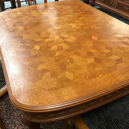 Lovely carved French Oak dining table with a parquetry top and six matching upholstered chairs in good original detailed condition.