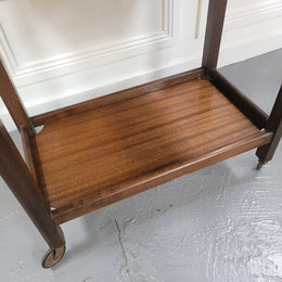 Oak drop leaf auto trolley on wheels. Both sides open up to make a larger table. It is in good original detailed condition.