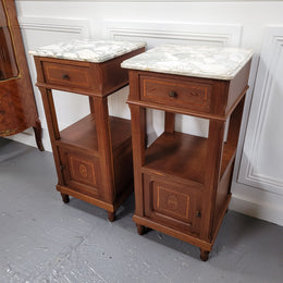 Pair of Antique French Oak Louis XVI style marble top bedside cabinets. They have decorative inlay and have been sourced from France. They are in good original detailed condition.