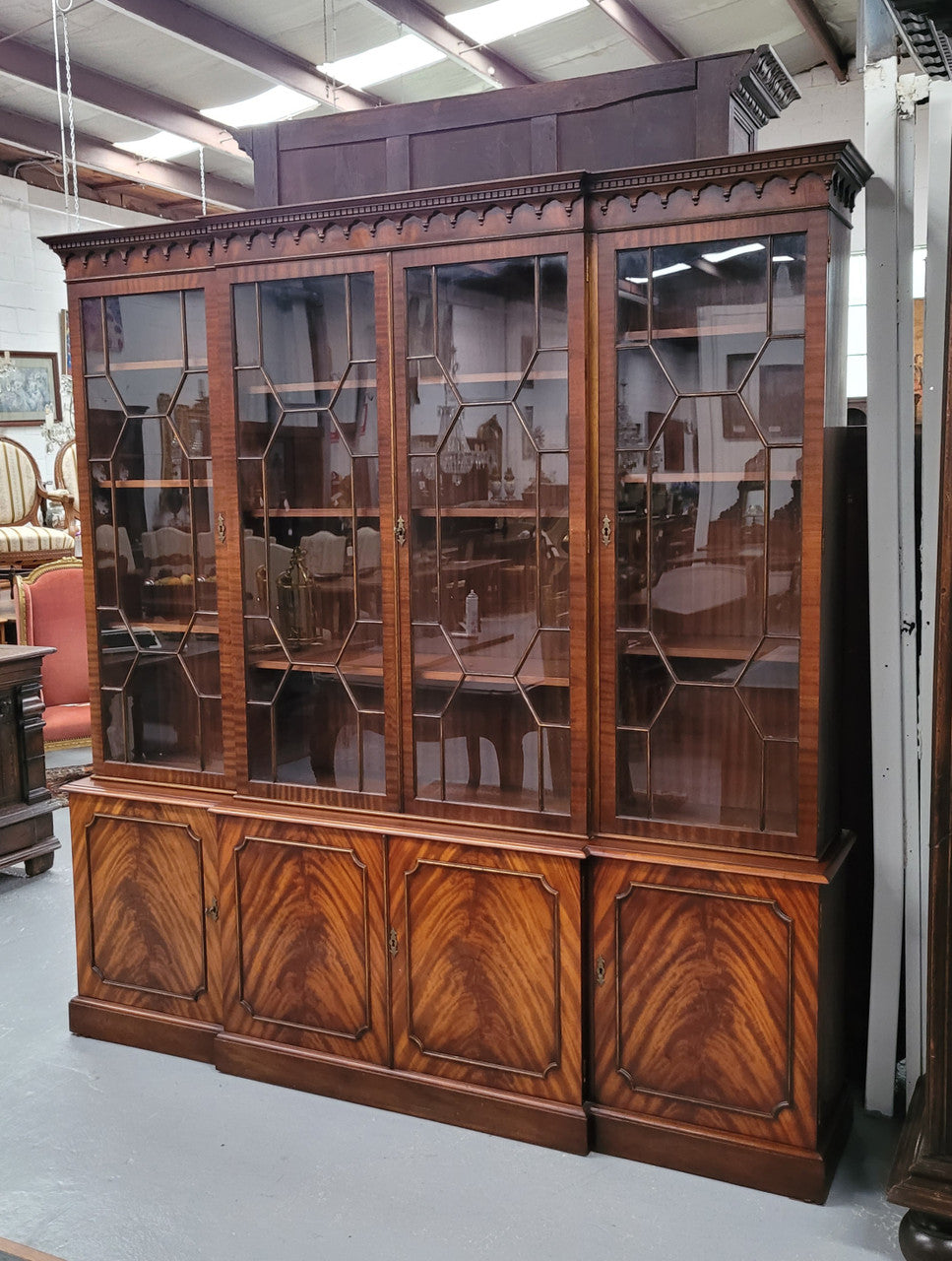 Georgian style Breakfront Flame Mahogany four door bookcase. A very impressive piece with plenty of storage and is of pleasing narrow proportions. It has been sourced locally and is in good original detailed condition.