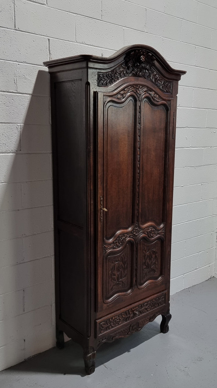 An Attractive French Louis XV style single-door ‘Marriage Armoire’. Beautifully arched crest with detailed carved flowers along with an arched single door which repeats the floral carvings. It is also has plenty of storage space with three adjustable shelves along with a drawer at the bottom. All in good original detailed condition.