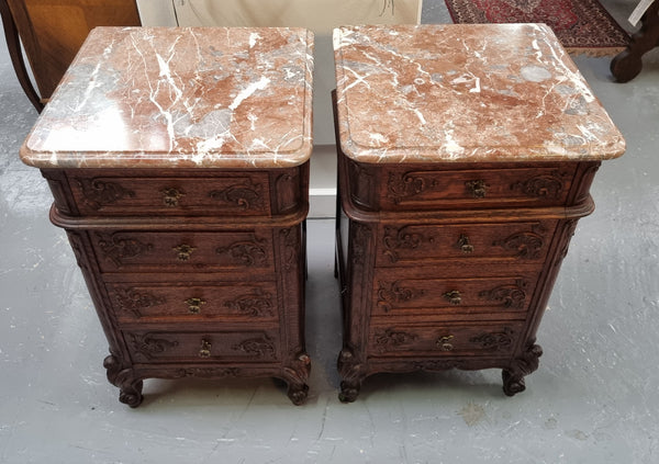 A pair of hard to find French Oak Louis XV style four drawer marble topped bedsides with attractive carvings. They are in good original detailed condition and have been sourced from France.
