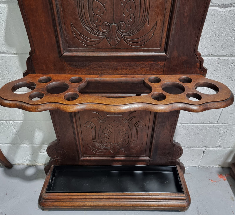 A beautiful Henry II style narrow French Oak hall stand. It has beautiful decorative carvings as well as 8 wooden hooks and storage for umbrellas and walking sticks. In good original detailed condition.