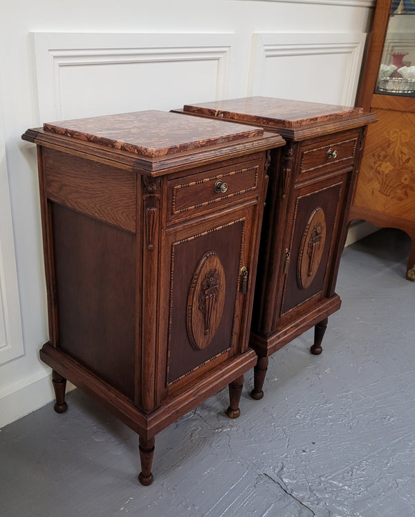 Pair of French Art Deco Oak and rouge inset marble top bedside cabinets. They have one drawer and one cupboard with elegant carving on the door. They have been sourced from France and are in good original detailed condition.