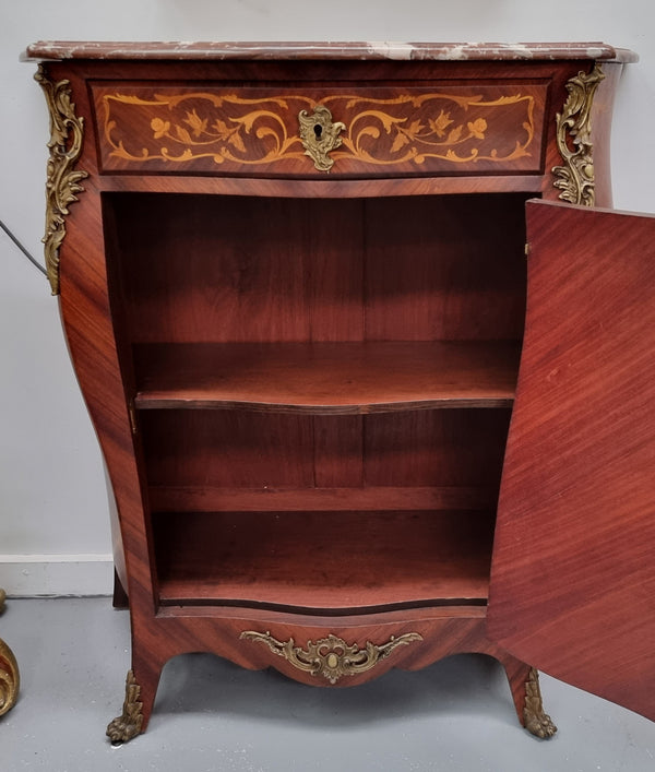 Stunning French Transitional style Mahogany marquetry inlay salon cabinet in the bombe shape. It has one draw, one shelf, marble top & ormolu decoration. Sourced from France and in good original detailed condition.