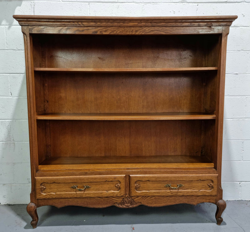 Lovely French Oak Louis XV style open shelf bookcase with two drawers for storage and three shelves in good original detailed condition.