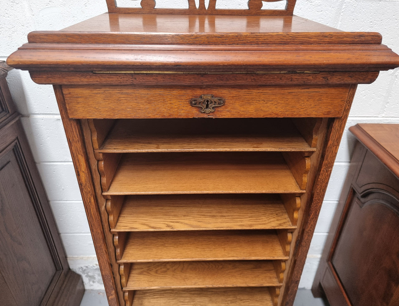 Antique Edwardian roll top Tambour file cabinet desk. This practical antique tambour front filing cabinet dates around 1900 in the Edwardian period and is constructed from Oak. This antique cabinet has an adjustable writing slope, above a tambour front with key and working lock. It has been sourced locally and is in good original detailed condition.