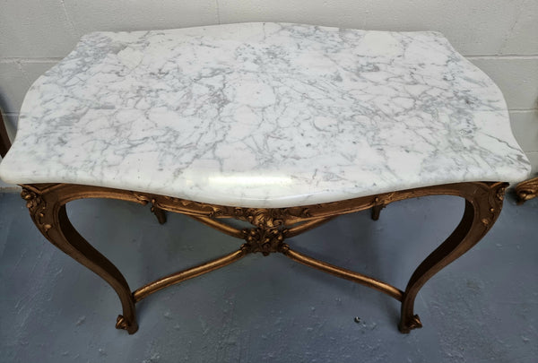 French Louis XV style carved center table with a stunning marble top and original gilt. In good original detailed condition.